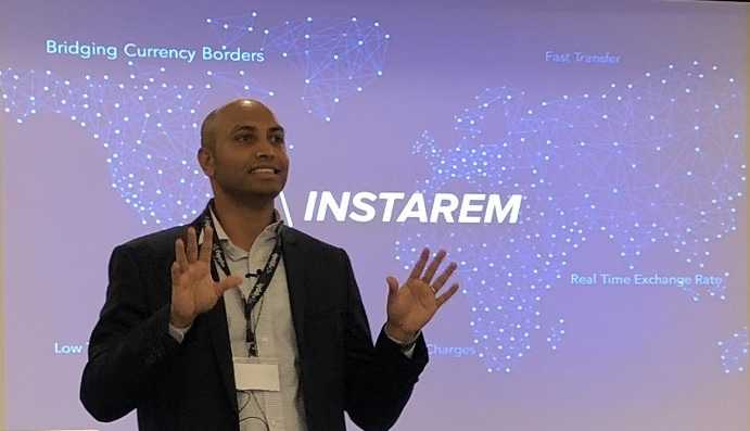 Prajit Nanu in front of instarem logo