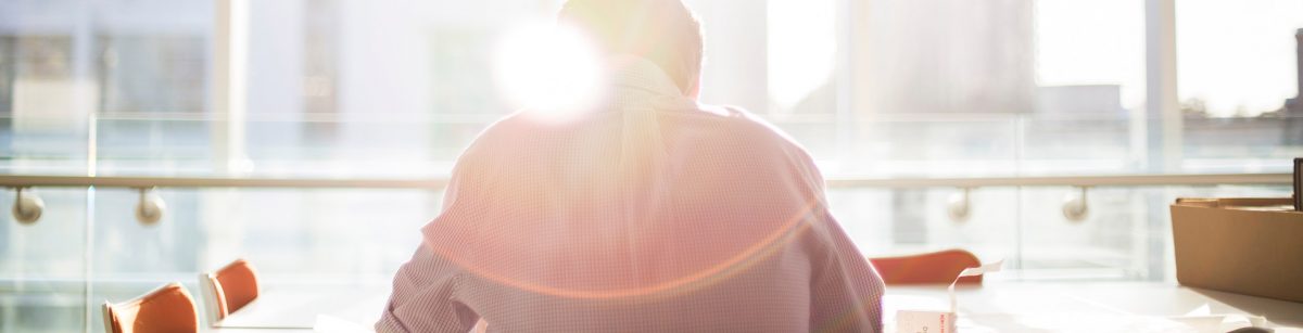 a man sat working with sunlight shining through the window