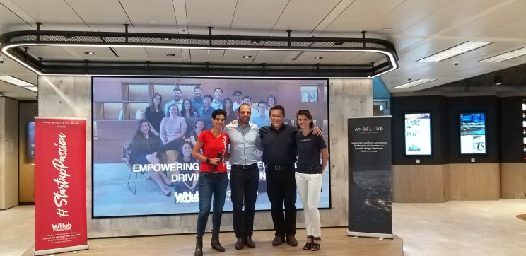 WHub & AngelHub founders stood in front of a digital screen after receiving investment